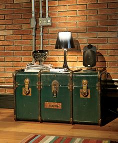 an old suitcase sitting on top of a wooden floor next to a lamp and rug