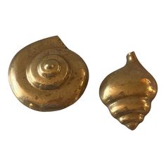 two gold shell shaped objects on a white background