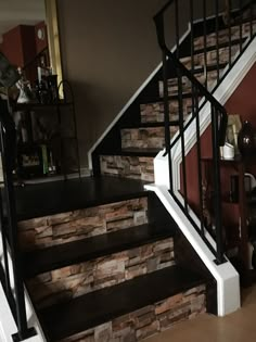 there is a stair case with stone walls on the bottom and second story landing area