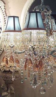 a chandelier hanging from the side of a wall in front of a mirror