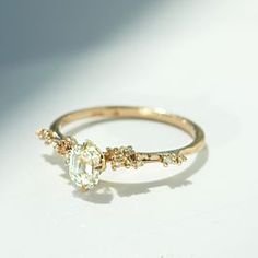 a yellow gold ring with an oval cut diamond surrounded by smaller round and baguettes