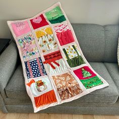 a couch with a blanket on top of it that has many different items in it