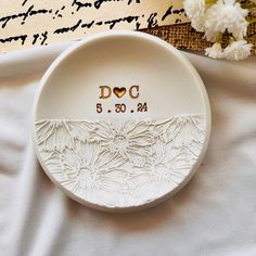 a white plate with the word doc printed on it next to some flowers and a piece of paper