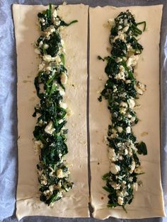 two flat breads with spinach and feta cheese on them sitting on a baking sheet