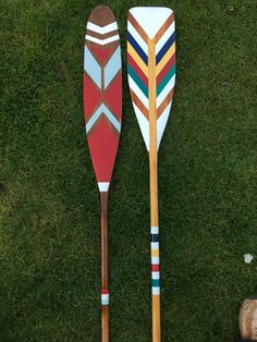 two wooden paddles sitting on top of green grass