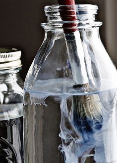 two glass jars with toothbrushes in them