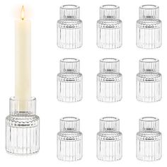 twelve clear glass jars with a lit candle in the middle and six smaller ones on each side