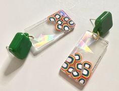 Holographic dangle / drop earrings with cute confetti baked into clear resin. Complete with super cool / distinctive green square posts! Surprisingly lightweight, too. Great statement earrings - perfect for PRIDE / LGBTQ celebrations! Would make a thoughtful and unique gift for pride month. Holo rainbow effect captured in shifting light - looks especially amazing in sunlight. See you at the parade! These handmade statement earrings are perfect for any occasion / special event - brunches, birthda Acexual Earrings, Unique Rainbow Drop Earrings, Quirky Handmade Multicolor Earrings, Cute Confetti, Lgbtq Jewelry, Lgbtq Earrings, Vibrant Rainbow Dangle Earrings, Pride Earrings, Boys Night