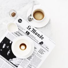 two cups of coffee on top of a newspaper