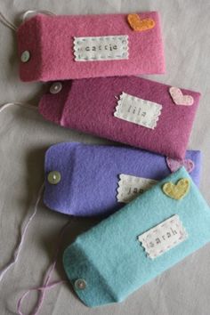 three small purses with hearts and name tags on them