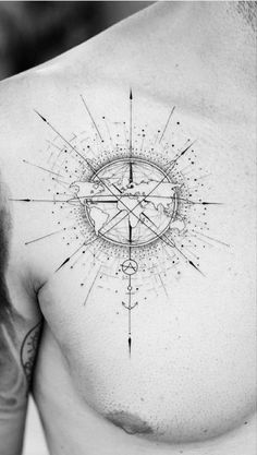 a man's chest with a compass tattoo on it