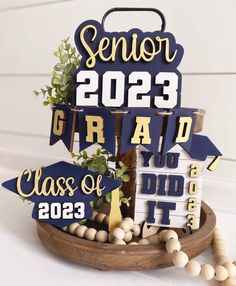 a graduation decoration made out of wood and some decorations on top of the sign that says class of 2013