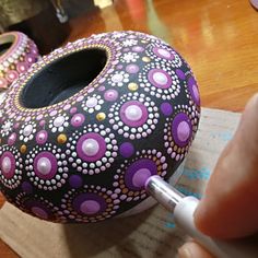 a person is painting a decorative object with acrylic paint