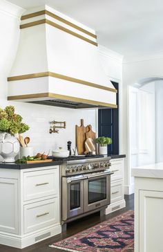 a stove top oven sitting inside of a kitchen next to a counter with utensils on it