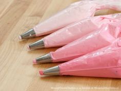 four pink umbrellas are sitting on the floor with plastic wrap around them and one has three silver tips