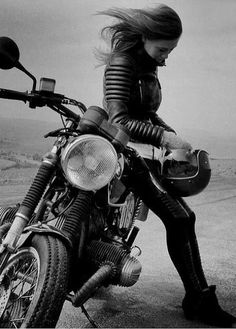 a woman sitting on top of a motorcycle