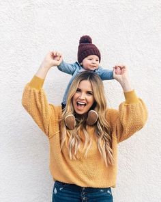 a woman holding a child on top of her head