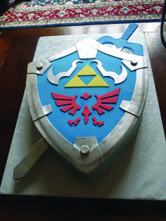 a cake that looks like the legend of zelda shield on top of a table