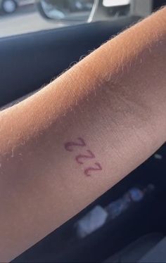 a close up of a person's arm with a number tattoo on the wrist