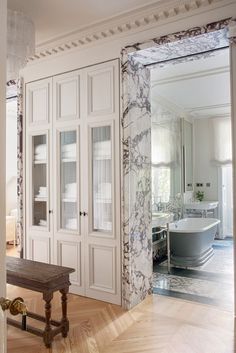 an ornate bathroom with marbled walls and flooring, along with a wooden bench