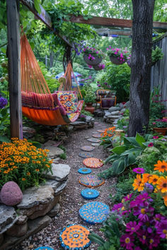 a garden with flowers, rocks and hammock hanging from the trees in it