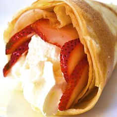 a crepe filled with strawberries and whipped cream