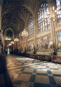 an ornate hall with chandeliers and paintings on the walls, along with marble benches