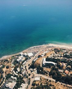 an aerial view of a city by the ocean and beach with lots of sand in it