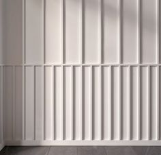 an empty room with white paneled walls and tile flooring on the wall is a radiator