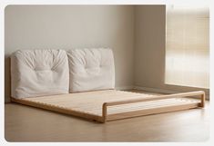 a bed with white sheets and wooden slats