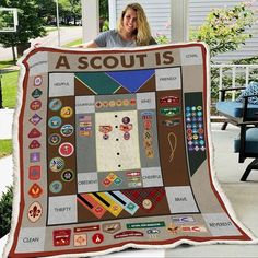 a woman is holding up a quilt made to look like a scout's square