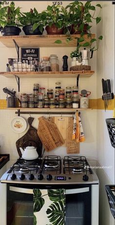 a stove top oven sitting inside of a kitchen next to a shelf filled with pots and pans