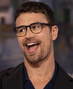 a close up of a person wearing glasses with a surprised look on his face and mouth