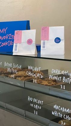 donuts are lined up on the counter at this deli shop, with price tags attached to them