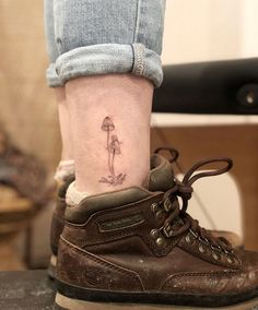 a woman's foot with a small mushroom tattoo on her left side calfocks