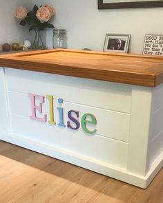 a white storage box with the word elsie painted on it's sides and wooden lid