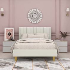 a white bed sitting next to a pink wall with a mirror on the wall above it