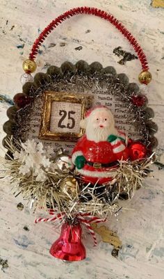 a christmas ornament hanging on a wall next to a clock and tinsel