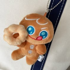 a brown teddy bear with blue eyes is on a chain