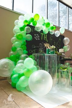 green and white balloons in front of a blackboard