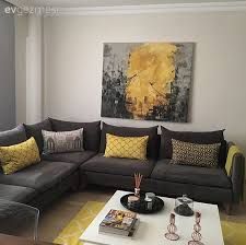 a living room with grey couches and yellow pillows on the coffee table in front of it