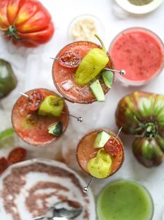 several glasses filled with different types of drinks and garnished with kiwis