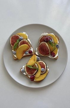 four pieces of fruit and cream on a white plate