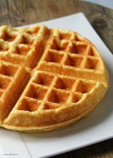 a white plate topped with two waffles on top of a wooden table