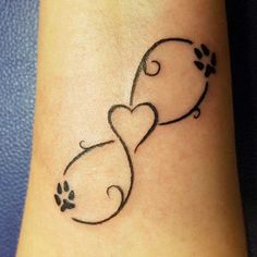 a dog paw and heart tattoo on the ankle or foot, with an arrow in the shape of a cat's tail