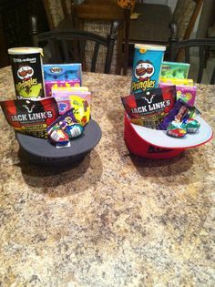 two hats sitting on top of a table filled with snacks and candy bar wrappers