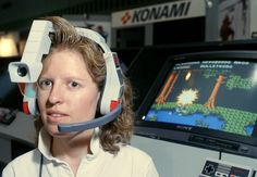 a woman wearing headphones in front of a computer screen with a video game on it