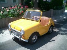 an old yellow car is parked on the street