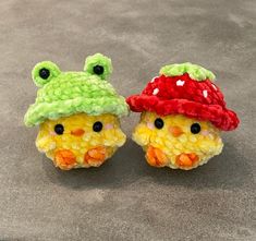 two small crocheted animals with hats on their heads, one is yellow and the other is green