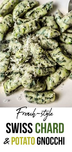 a white plate topped with green pasta covered in sauce and parmesan sprinkles